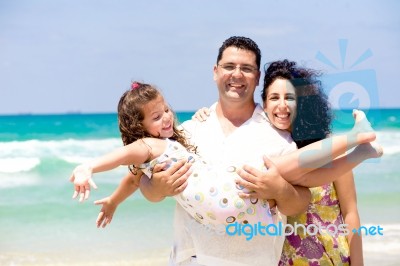 Family Enjoying On The Beach Stock Photo