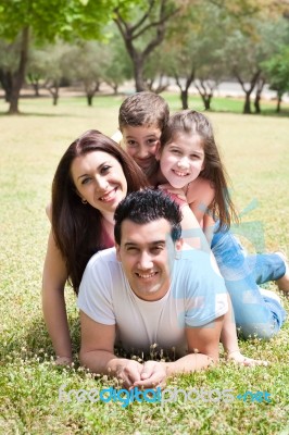 Family Lying In Grass Field Stock Photo