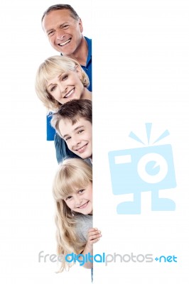 Family Of Four Behind Blank Whiteboard Stock Photo