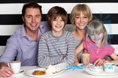 Family Of Four Having Great Time In Restaurant Stock Photo