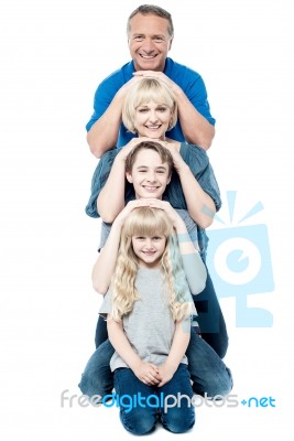 Family Of Four Posing In A Row Stock Photo