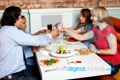 Family Raising A Toast Before Dinner Stock Photo