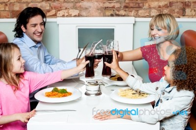 Family Raising Their Glasses Before Eating Stock Photo