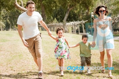 Family Running With Two Young Children Stock Photo