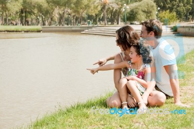 Family Sitting Near The Lake Stock Photo