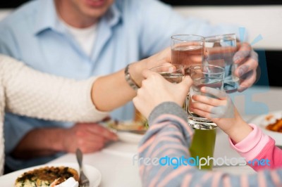 Family Toasting Water Glasses In Celebration Stock Photo