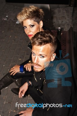 Fashion Young Couple Sitting At The Bus Stop Stock Photo