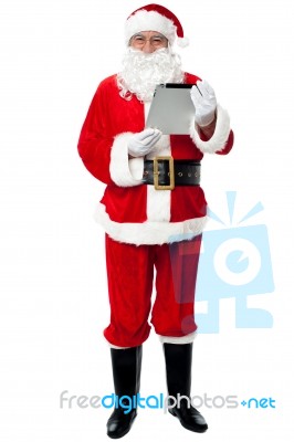 Father Christmas Using New Tablet Device Stock Photo