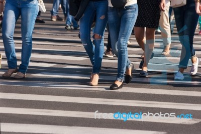 Feet Of Pedestrians Walking On The Crosswalk Stock Photo