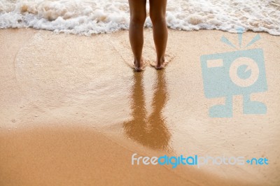 Feet Of The Person Standing In The Water Stock Photo