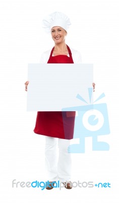 Female Chef Displaying Blank White Ad Board Stock Photo