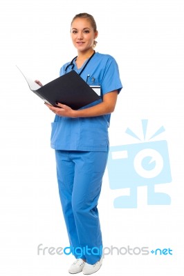 Female Doctor Reviewing Reports Stock Photo