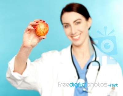 Female Doctor Showing An Apple Stock Photo