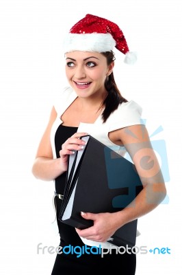 Female Employee Holding Files Wearing Santa Cap Stock Photo