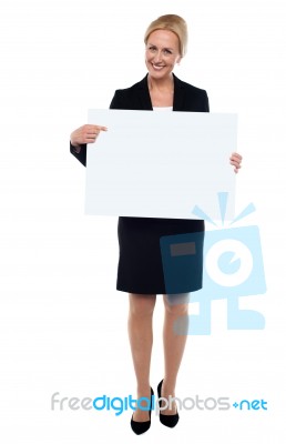 Female Executive Pointing Towards White Ad Board Stock Photo