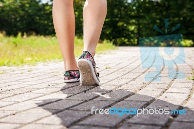 Female Feet On The Sidewalk Closeup Stock Photo