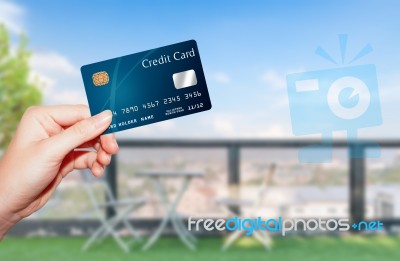 Female  Hand Holding Credit Card Against Terrace View And Bluesk… Stock Photo