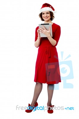 Female In Santa Cap Using Tablet Pc Stock Photo