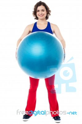 Female Instructor Displaying Pilates Ball Used In Gym Stock Photo