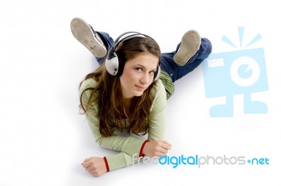 Female Lying And Listening Music Stock Photo