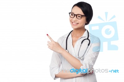 Female Physician Pointing And Looking Away Stock Photo