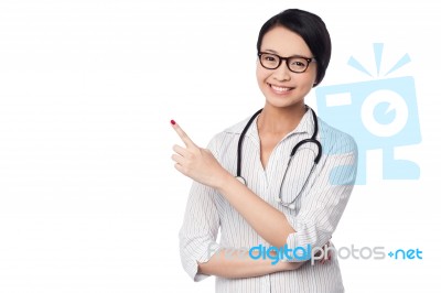 Female Physician Pointing And Looking Away Stock Photo