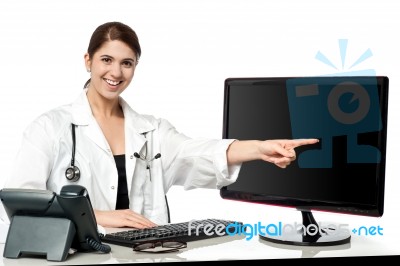 Female Physician Pointing At Computer Screen Stock Photo