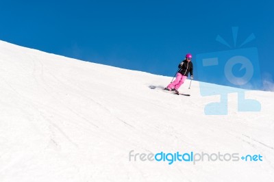 Female Skier In Fresh Powder Snow And Blue Sky Stock Photo