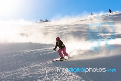 Female Skier In Fresh Powder Snow And Sunlight Stock Photo