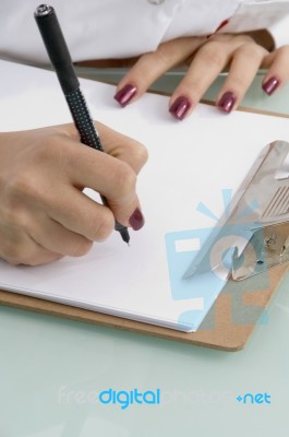 Female Writing On Clipboard Stock Photo