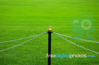 Fence Of Chain On Green Grass Stock Photo