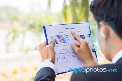 Finger Of Business Man Pointing To The Paper Report Stock Photo