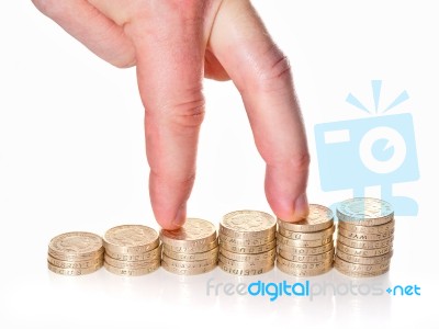 Fingers Walking Up On Stacks Of One Pound Coins Stock Photo