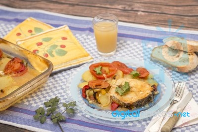 Fish With Potatoes And Tomato Stock Photo