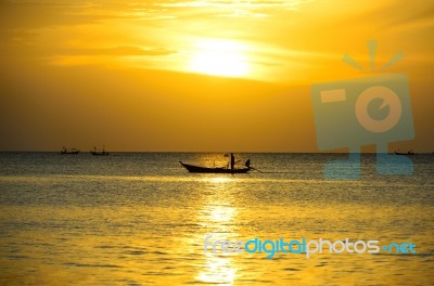 Fisherman In Sea At Sunset Stock Photo