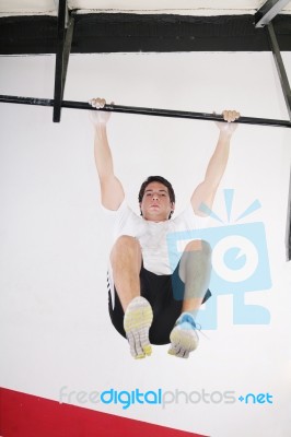 Fit Man Performing Pull Ups In Bar Stock Photo