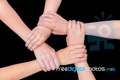 Five Arms Of Children Holding Together On Black Background Stock Photo