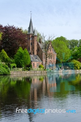 Flemish Style Castle Reflecting In Minnewater Lake In Bruges Stock Photo