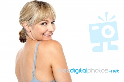 Flirtatious Woman Turning Back And Passing A Smile Stock Photo