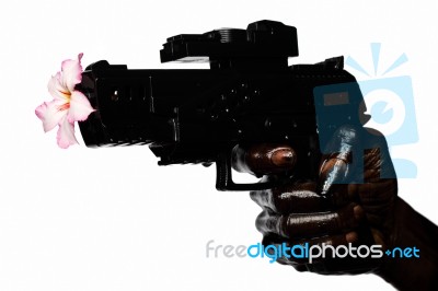 Flower And Gun Held By Hand Stained With Engine Oil Stock Photo