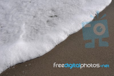 Foam On Sand Stock Photo