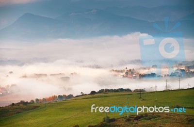 Foggy Sunny Morning In Mountain Village. Misty Hills Stock Photo