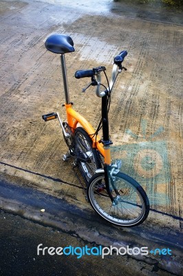 Folding Bicycle On Wet Road Stock Photo