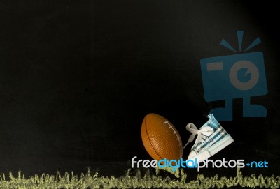 Football On Tee With One Shoe In Black Background Stock Photo