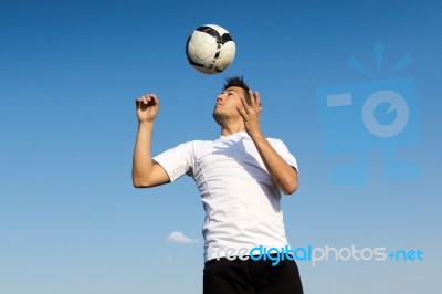 Football Player Striking The Ball At The Stadium Stock Photo