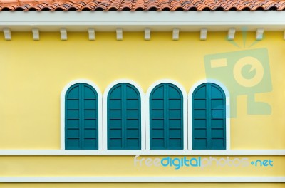 Four Green Arched Windows On Yellow Wall Stock Photo