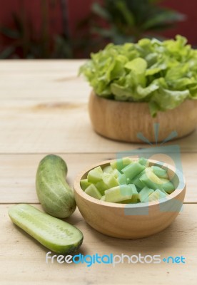 Fresh Cucumber And Green Lettuce In Wooden Bowl Stock Photo