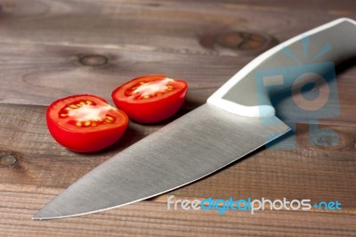 Fresh Cut Tomatoes With Knife On The Dark Wooden Table Stock Photo