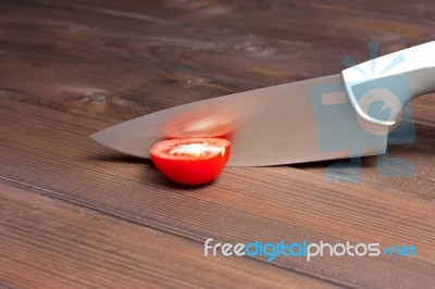 Fresh Cut Tomatoes With Knife On The Dark Wooden Table Stock Photo