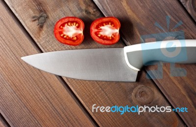 Fresh Cut Tomatoes With Knife On The Dark Wooden Table Stock Photo